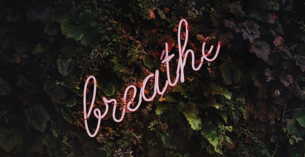 Pink neon light that says breath